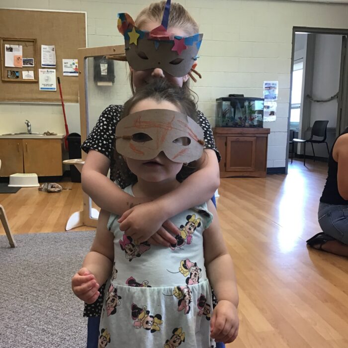 Sister guardians wearing masks and capes while posing for photo.
